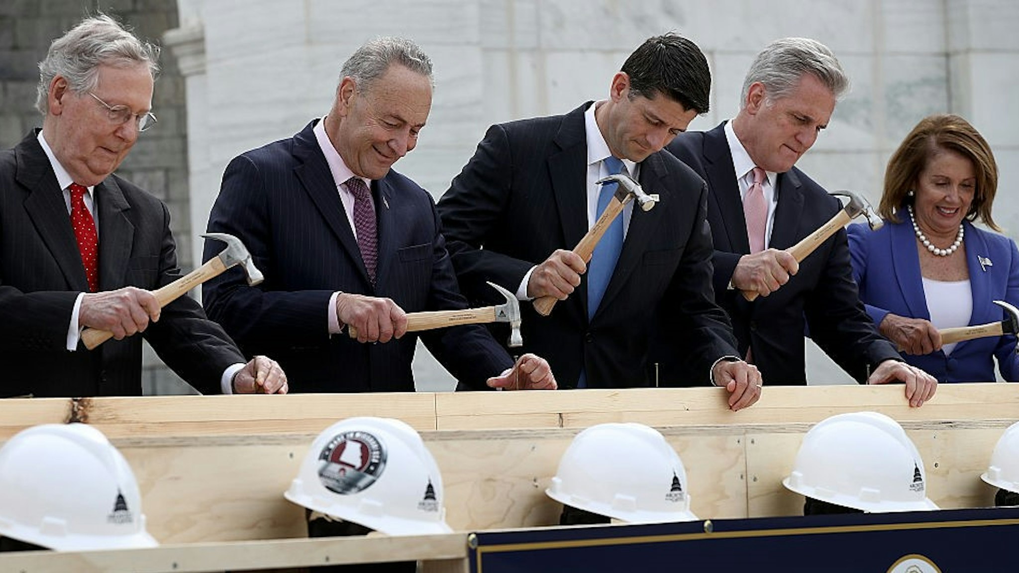 WASHINGTON, DC - SEPTEMBER 21: (L-R) Senate Majority Leader Mitch McConnell (R-KY), Sen. Chuck Schumer (D-NY), Speaker of the House Paul Ryan (R-WI), House Majority Leader Kevin McCarthy (R-CA) and House Minority Leader Nancy Pelosi (D-CA) drive nails into a piece of lumber at the "First Nail Ceremony" September 21, 2016 outside the U.S. Capitol in Washington, DC. The ceremony marked the official launch of construction on the Inaugural platform where the next President of the United States will take the oath of office on Friday, January 20, 2017. (Photo by