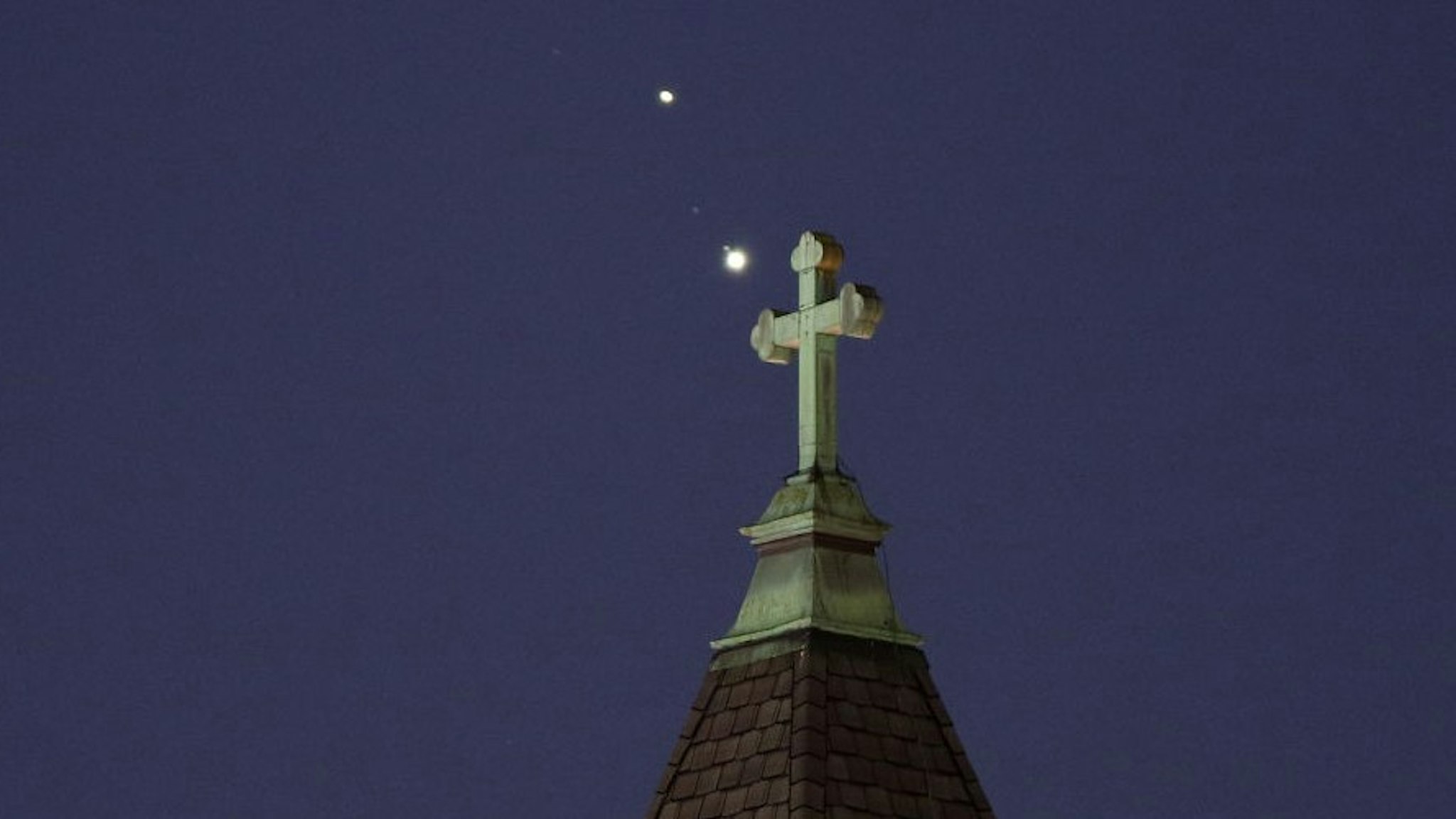 JERSEY CITY, NJ - DECEMBER 18: Saturn and Jupiter set behind a church ahead of their conjunction that is being called The Christmas Star next week on December 18, 2020 in Jersey City, New Jersey. (Photo by