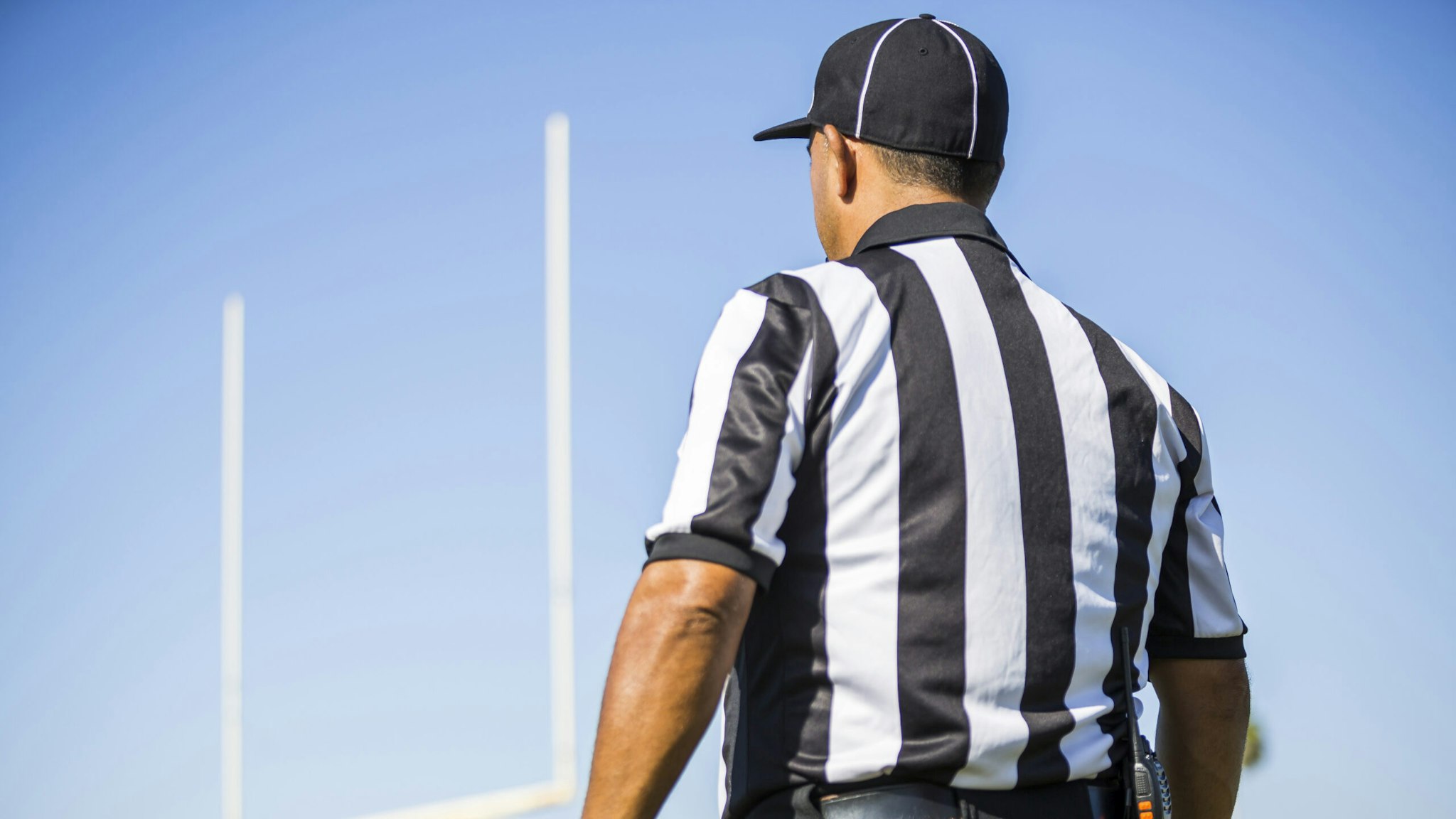 Rear view of football referee wearing black and white striped shirt
