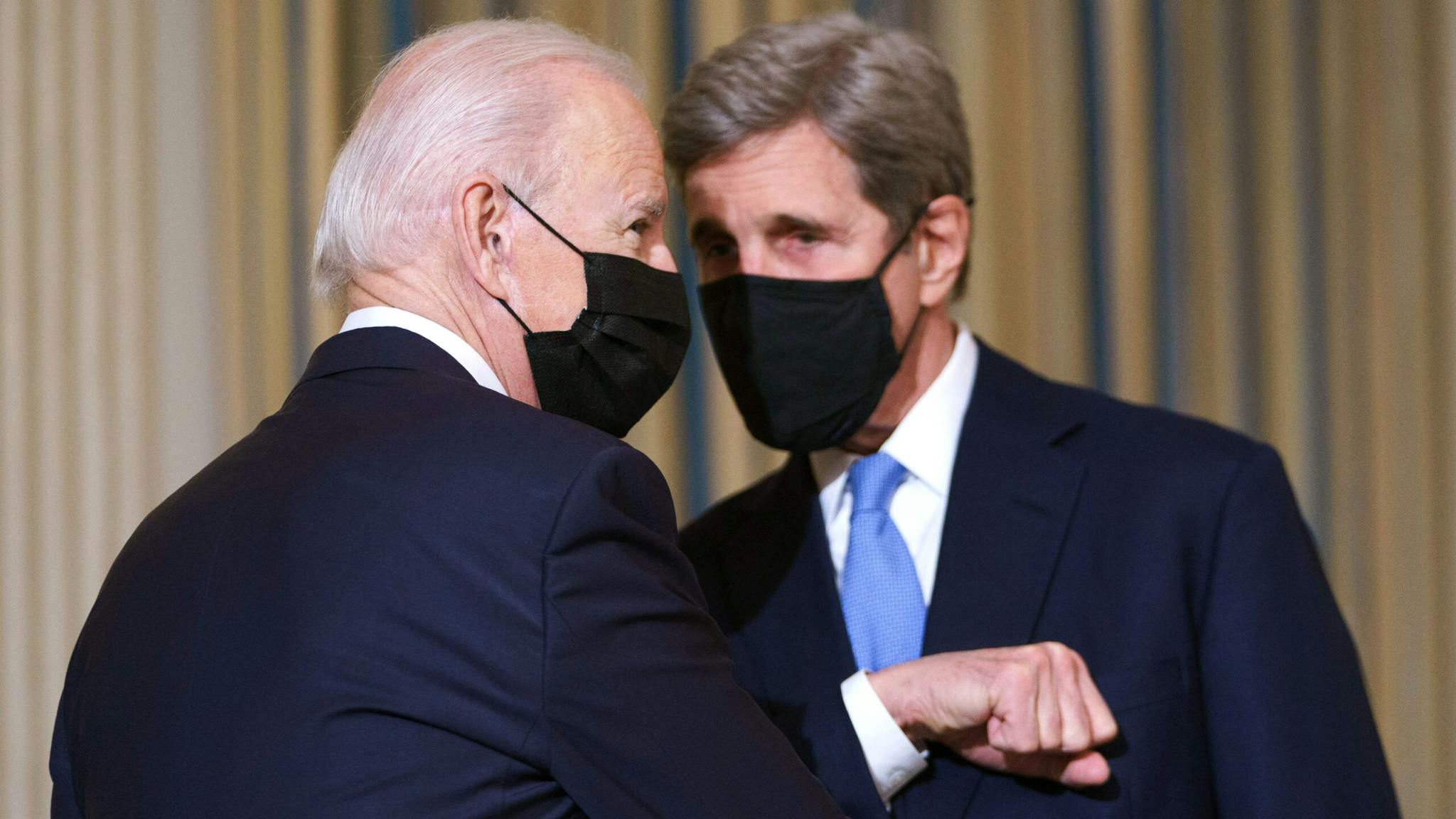 TOPSHOT-US-POLITICS-BIDEN-CLIMATE TOPSHOT - US President Joe Biden greets Special Presidential Envoy for Climate John Kerry as he arrives to speak on climate change before signing executive orders in the State Dining Room of the White House in Washington, DC on January 27, 2021.