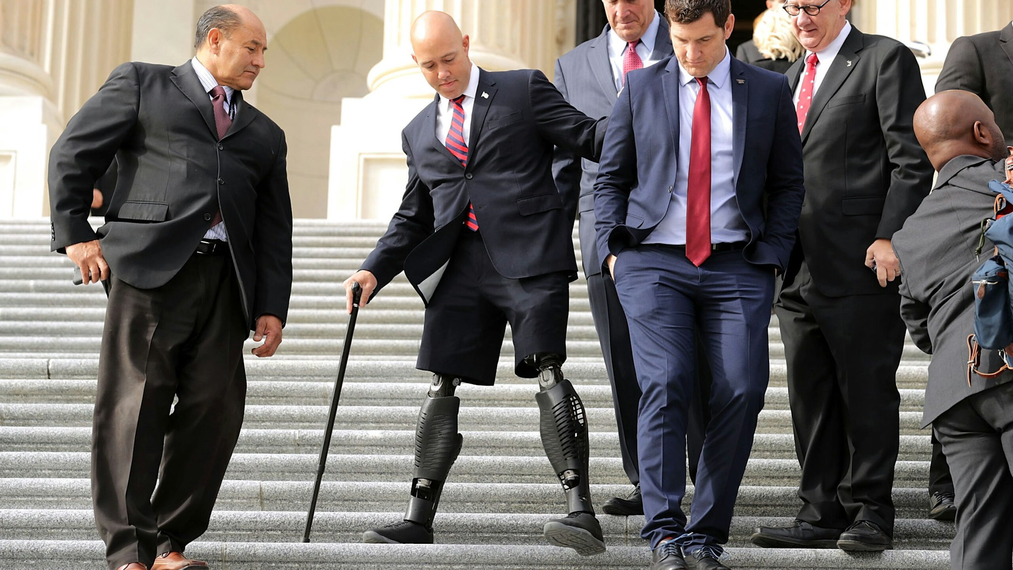 WASHINGTON, DC - NOVEMBER 15: Incoming Republican and Democratic members of Congress, including former U.S. Army Special Operations soldier and Representative-elect Brian Mast (R-FL) (2nd L), walk down the steps of the House of Representatives before posing for a group photograph November 15, 2016 in Washington, DC. There are 50 members of the freshmen class that will join the 115th Congress when it begins in January 2017.