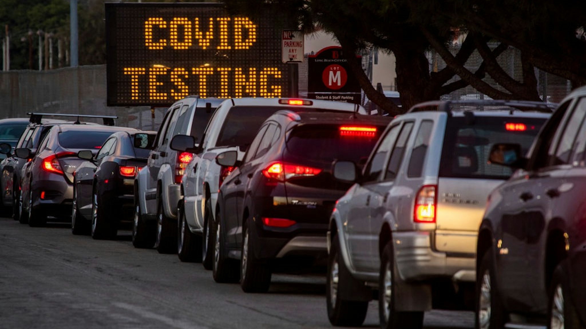 LONG BEACH, CA - December 09: A long line of vehicles line up to take COVID-19 tests at dusk at Long Beach City College-Veterans Memorial Stadium on Wednesday, Dec. 9, 2020 in Long Beach, CA.