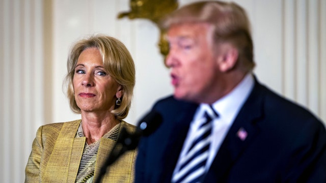 Betsy DeVos, U.S. secretary of education, listens as U.S. President Donald Trump, right, speaks during the National Teacher of the Year (NTOY) reception in the East Room of the White House in Washington, D.C., U.S., on Wednesday, May 2, 2018. The NTOY program is run by the Council of Chief State School Officers which began in 1952 and highlights excellence in teaching.