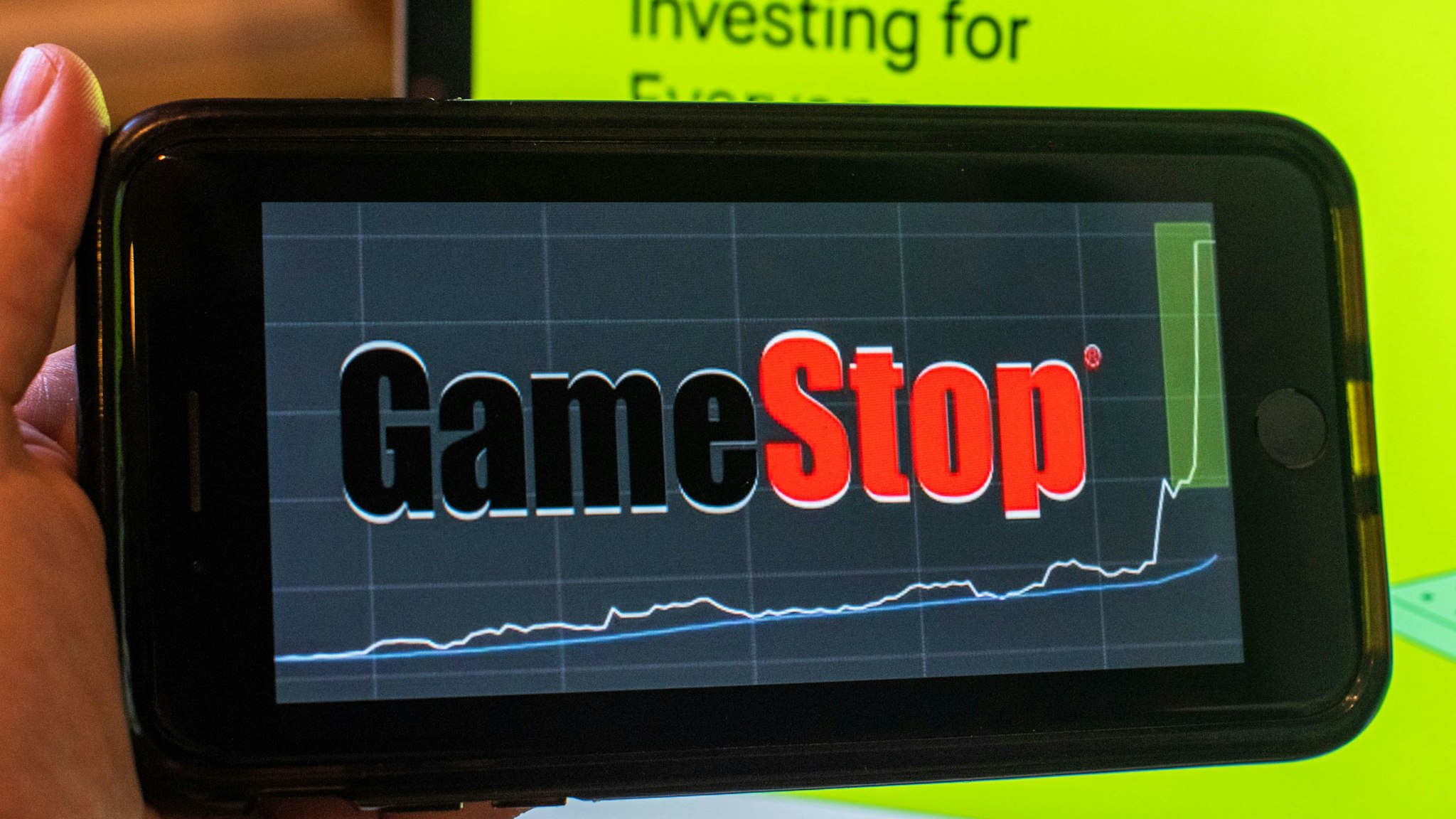 The GameStop Corp. logo on a smartphone and the Robinhood website on a laptop computer arranged in Hastings-On-Hudson, New York, U.S., on Friday, Jan. 29, 2021. GameStop Corp. advanced on Friday and was on track to recoup much of Thursdays $11 billion blow after Robinhood Markets Inc. and other brokerages eased trading restrictions on the video-game retailer.