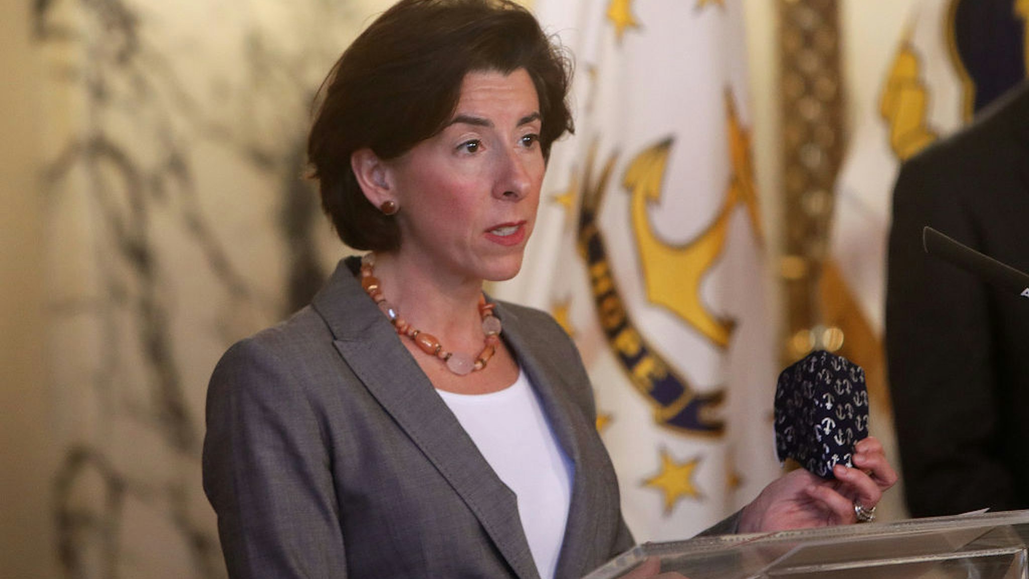 Rhode Island Governor Gina Raimondo, holding her mask in her left hand, speaks during a press conference in Providence, RI on April 14, 2020.