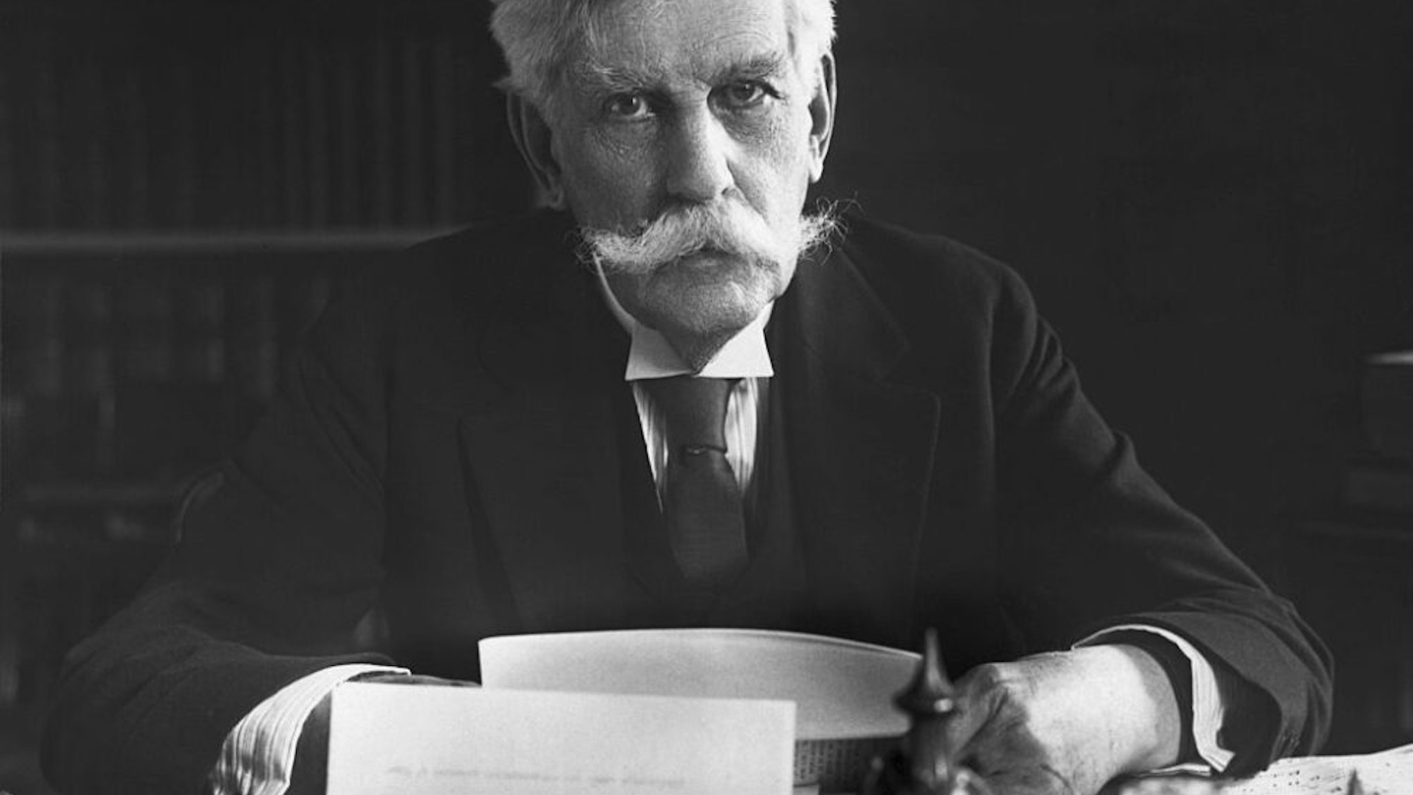 Oliver Wendell Holmes (1841-1935), Associate Justice of the Supreme Court, is shown seated at his desk.