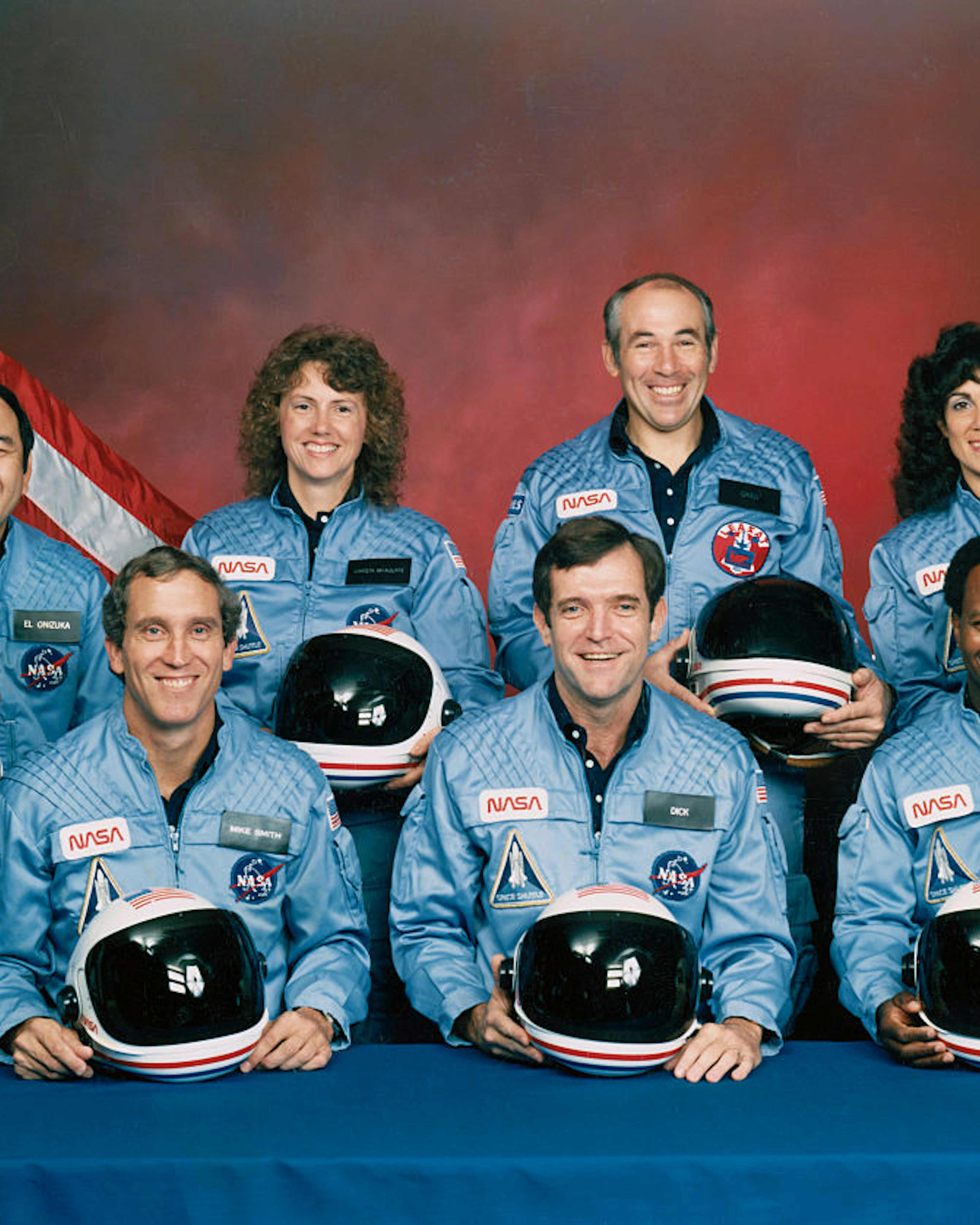 (Original Caption) Five astronauts and two payload specialists make up the STS 51-L crew, scheduled to fly aboard the Space Shuttle Challenger in January of 1986. Crewmembers are (left to right, front row) astronauts Michael J. Smith, Francis R. (Dick) Scobee and Ronald E. McNair; and Ellison S. Onizuka, Sharon Christa McAuliffe, Gregory Jarvis and Judith A. Resnik. McAuliffe and Jarvis are payload specialists, representing the Teacher in Space Project and Hughes Co., respectively.