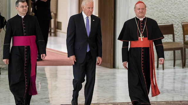 US Vice President Joe Biden (C) is flanked by Cardinal Gianfranco Ravasi (R) as he arrives to attend a special audience celebrates by Pope Francis with participants at a congress on the progress of regenerative medicine and its cultural impact in the Paul VI hall in Vatican City, Vatican on April 29, 2016.(Photo by Giuseppe Ciccia/NurPhoto via Getty Images)