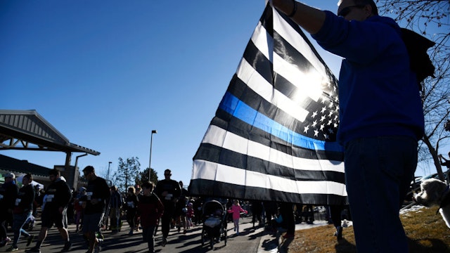 Bruce Workman shows his support holding the Thin Blue Line flag during the Zackari Parrish 5K run/walk at the Douglas County Fairgrounds February 03, 2018.
