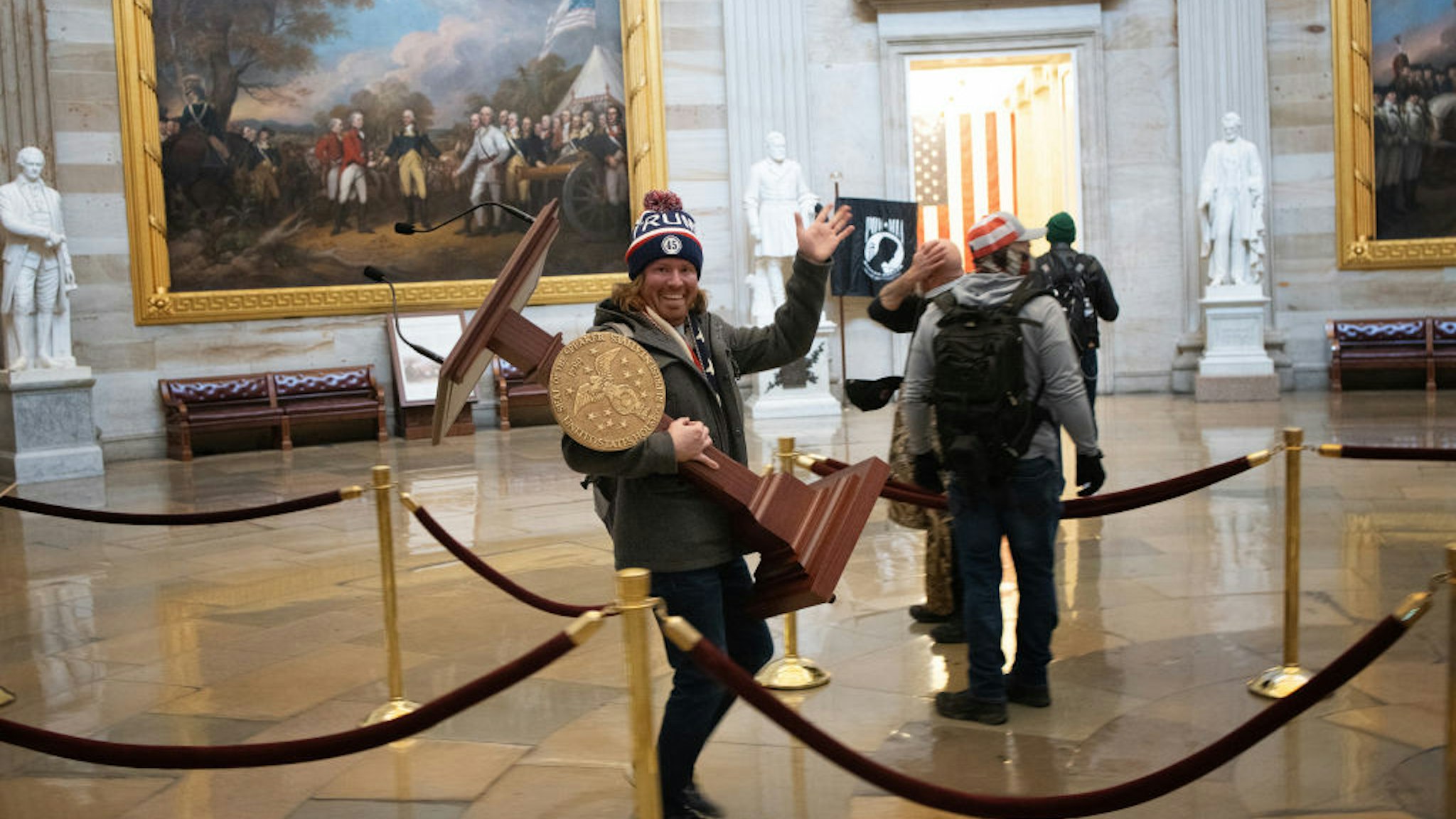 WASHINGTON, DC - JANUARY 06: A pro-Trump protester carries the lectern of U.S. Speaker of the House Nancy Pelosi through the Roturnda of the U.S. Capitol Building after a pro-Trump mob stormed the building on January 06, 2021 in Washington, DC. Congress held a joint session today to ratify President-elect Joe Biden's 306-232 Electoral College win over President Donald Trump. A group of Republican senators said they would reject the Electoral College votes of several states unless Congress appointed a commission to audit the election results.