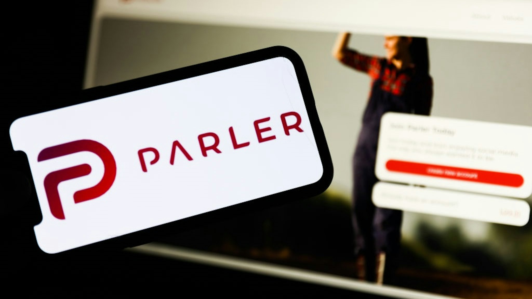 Parler app logo displayed on a phone screen and Parler website displayed on a laptop screen are seen in this illustration photo taken in Poland on January 10, 2020.
