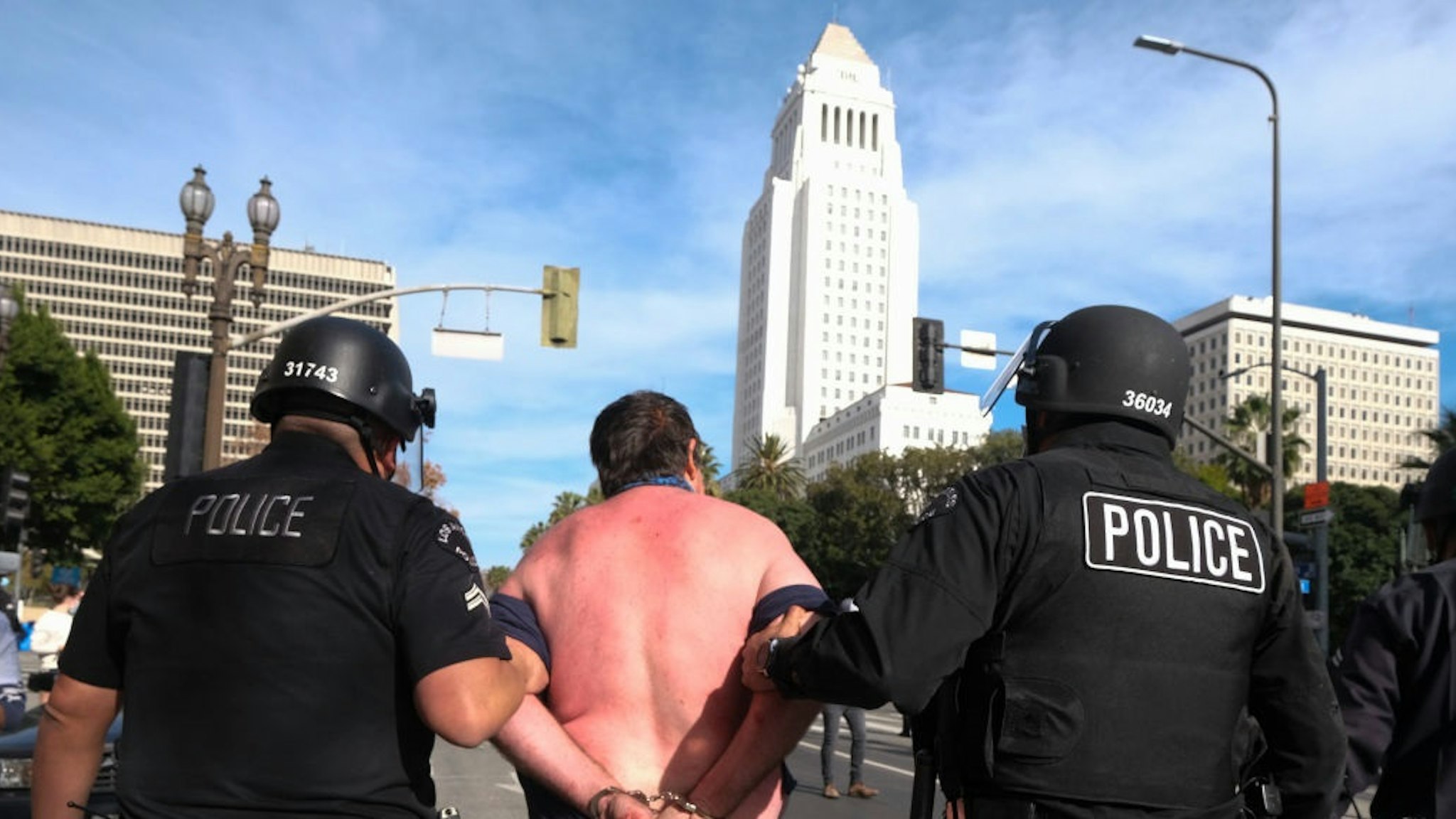 Los Angeles City Hall is seen as Police officers detain a protester caught in a fight during a protest in support of US President Donald Trump in Los Angeles on January 6, 2021.