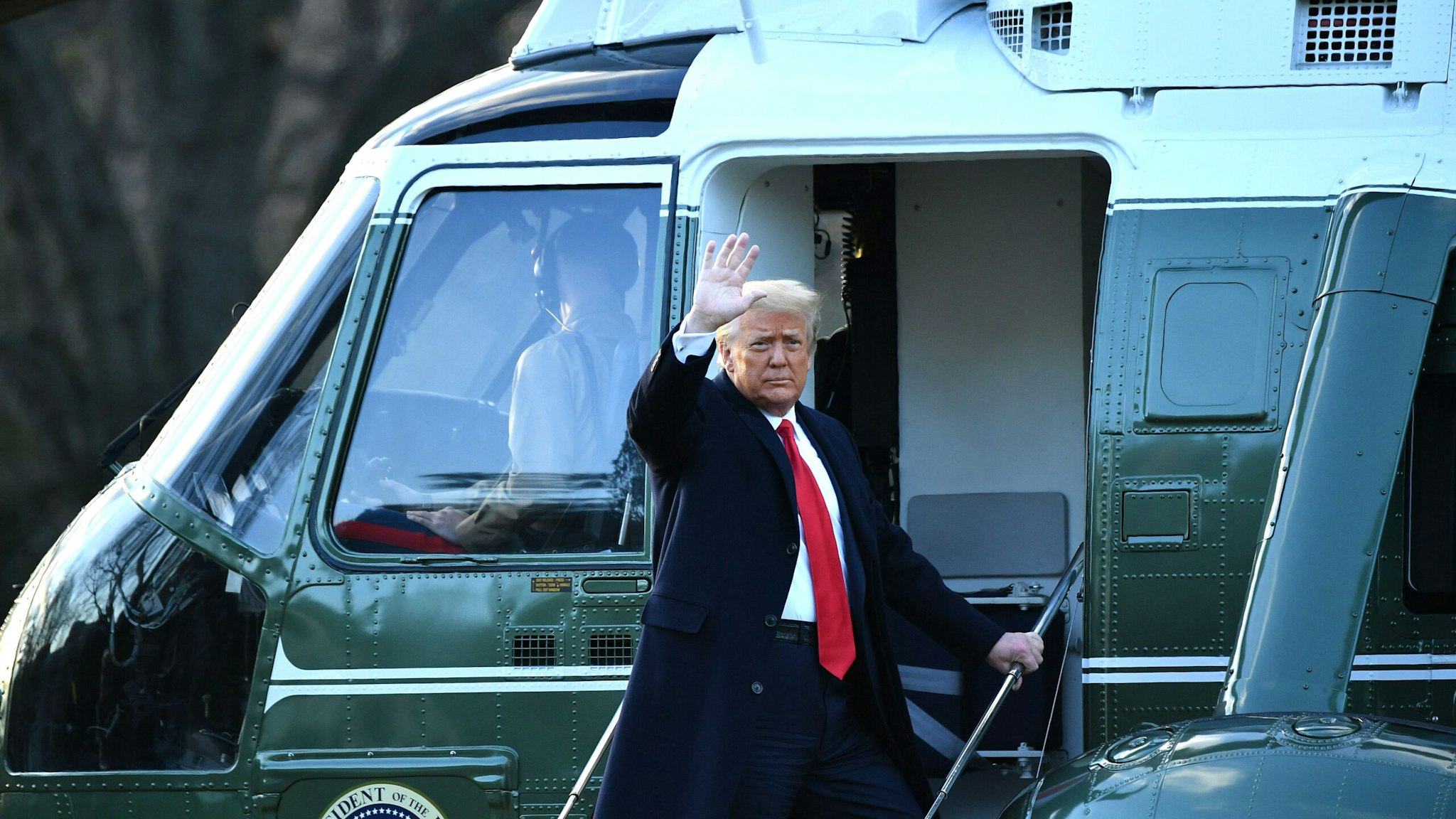 TOPSHOT - Outgoing US President Donald Trump waves as he boards Marine One at the White House in Washington, DC, on January 20, 2021. - President Trump travels his Mar-a-Lago golf club residence in Palm Beach, Florida, and will not attend the inauguration for President-elect Joe Biden.