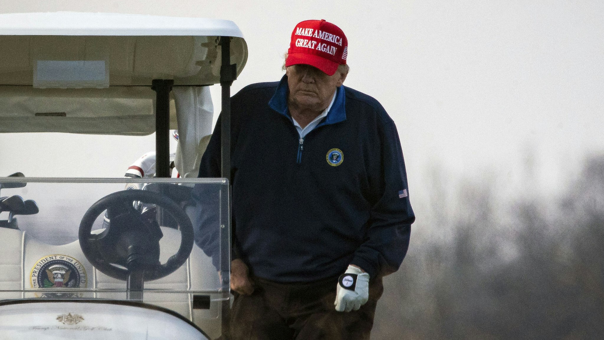 STERLING, VA - DECEMBER 13: U.S. President Donald Trump climbs into golf cart number 45 as he golfs at Trump National Golf Club on December 13, 2020 in Sterling, Virginia.