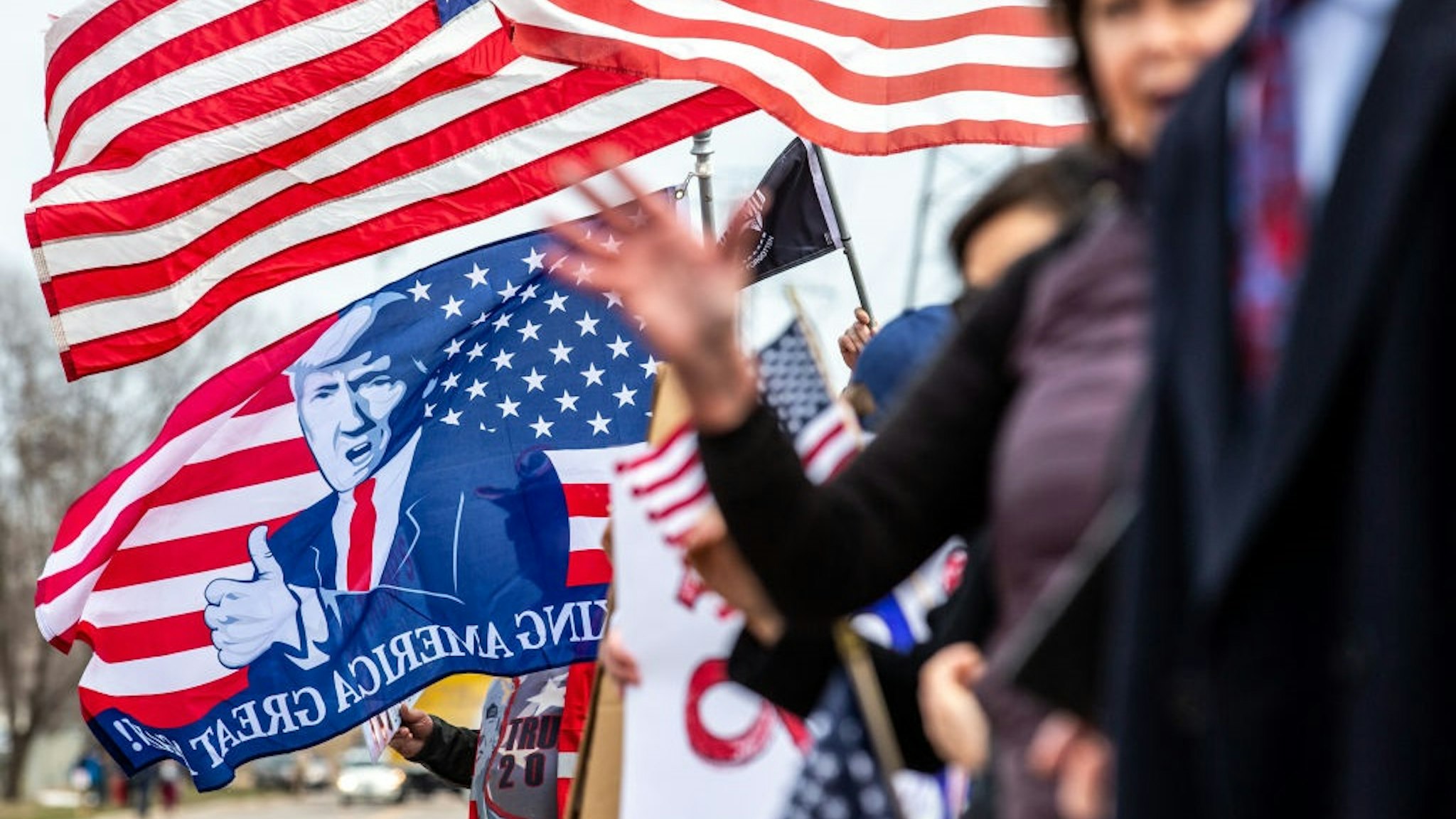 Trump supporters display US flags and signs as the Minnesota chapter of the Council on American-Islamic Relations (CAIR-MN) and a coalition of community organizations in support of Minnesota Representative Ilhan Omar gathered outside the Nuss Truck and Equipment in Burnsville, Minnesota where US President Donald Trump spoke on April 15, 2019.