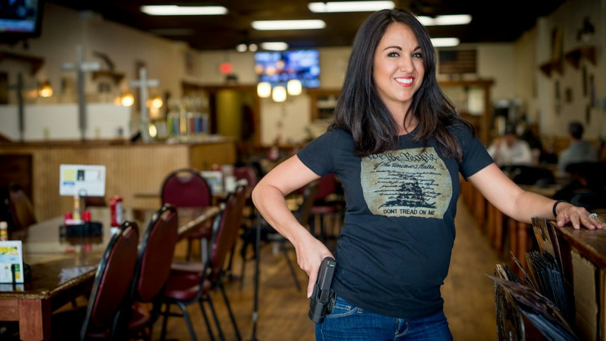 Owner Lauren Boebert poses for a portrait at Shooters Grill in Rifle, Colorado on April 24, 2018. - Lauren Boebert opened Shooters Grill in 2013 with her husband Jason in the small town of Rifle, Colorado, the only city in the United States named after a gun according to them. Shortly after Boebert opened the restaurant, there was a murder in the alley behind it. Boebert went next door to the Tradesmen Gun Store and Pawnshop to speak to the owner, Edward Wilks. Wilks explained to her that you dont need a permit in the state of Colorado to open carry. The next day she started carrying a gun with her. The majority of her staff carries, while it is not a requirement to work there she encourages them to do so if they feel comfortable with it. Customers are also welcome to carry firearms on them as well. The restaurants theme remained heavily country western but revolves alot around the theme of the Second Amendment as well. (Photo by EMILY KASK / AFP) (Photo credit should read