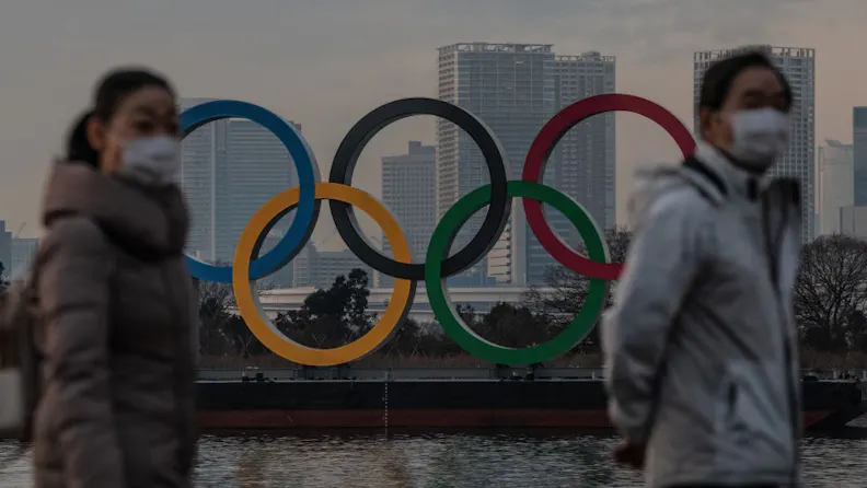 With 6 Months To Go, Speculation Mounts That Tokyo Olympics Could Be Cancelled TOKYO, JAPAN - JANUARY 22: People wearing face masks walk past the Olympic Rings on January 22, 2021 in Tokyo, Japan. With just six months to go until the start of the Games, it has been reported that the Japanese authorities have privately concluded that the Olympics could not proceed due to the ongoing Covid-19 coronavirus pandemic. Spokesmen from the IOC and Japanese government have since rejected the report. (Photo by