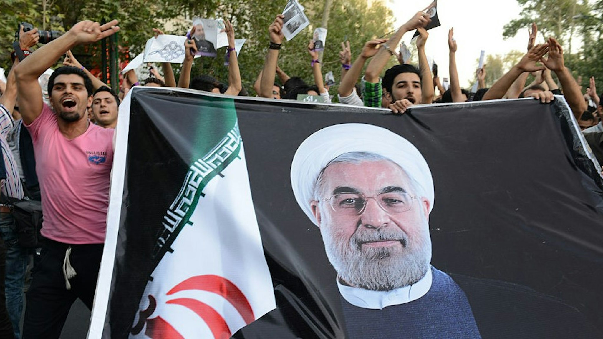 Youth supporters of Hasan Rouhani carry a huge banner with his photo imprinted on it three days prior to his presidential victory during a march on the street on June 12, 2013 in Tehran, Iran. On June 15th Rouhani's presidency was confirmed and announced by Iranian authorities. (Photo by