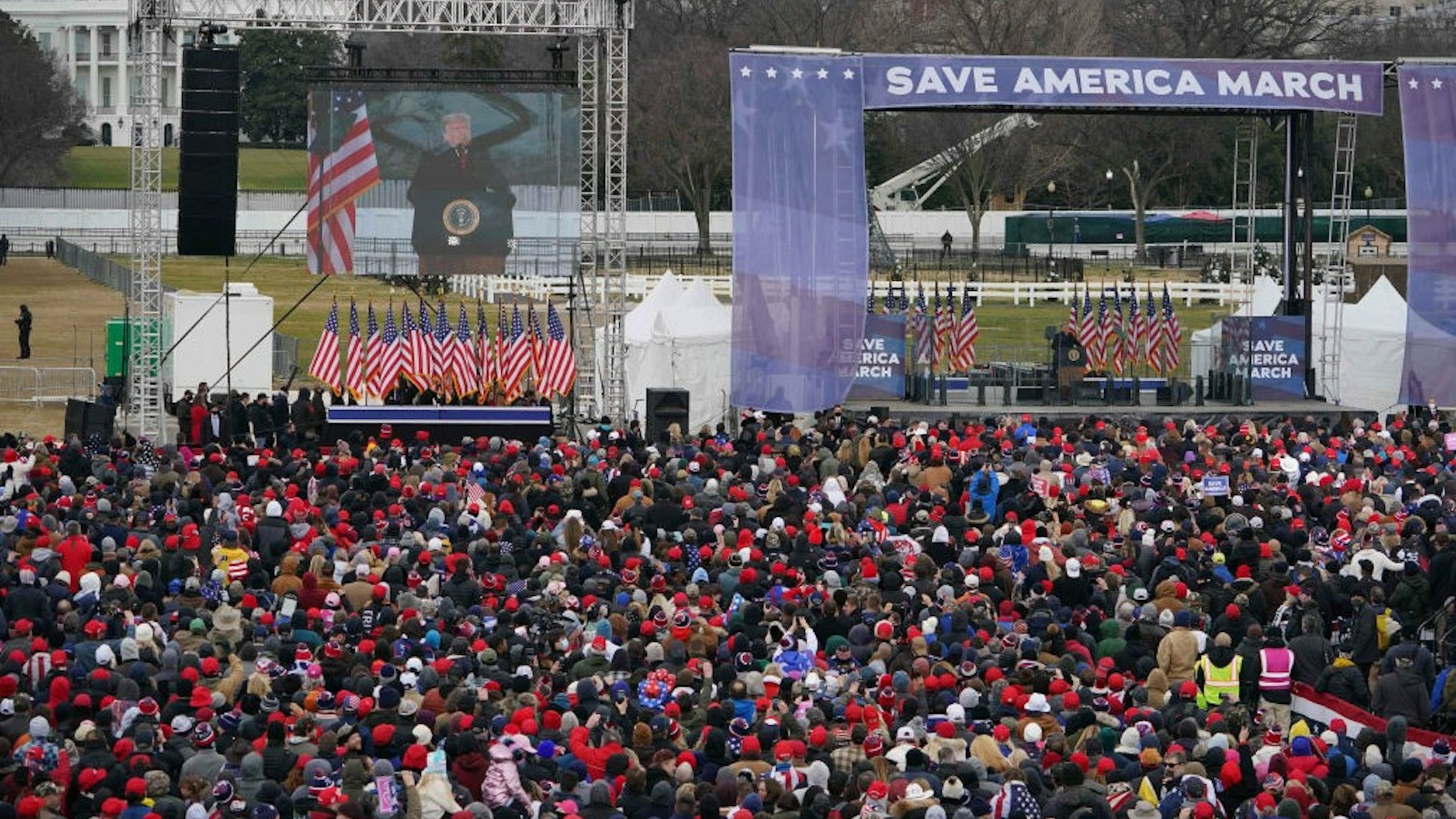 People gather as US President Donald Trump(C) speaks to supporters from The Ellipse near the White House on January 6, 2021, in Washington, DC. - Thousands of Trump supporters, fueled by his spurious claims of voter fraud, are flooding the nation's capital protesting the expected certification of Joe Biden's White House victory by the US Congress. (Photo by MANDEL NGAN / AFP) (Photo by