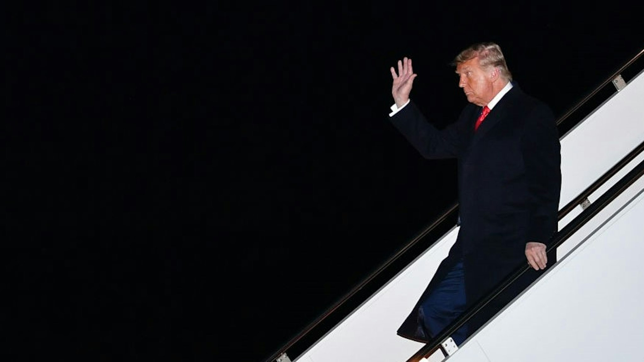 US President Donald Trump waves as he steps off Air Force One upon arrival at Andrews Air Force Base in Maryland on January 12, 2021. - US President Donald Trump comes back from touring a section of the border wall in Alamo, Texas. (Photo by MANDEL NGAN / AFP) (Photo by