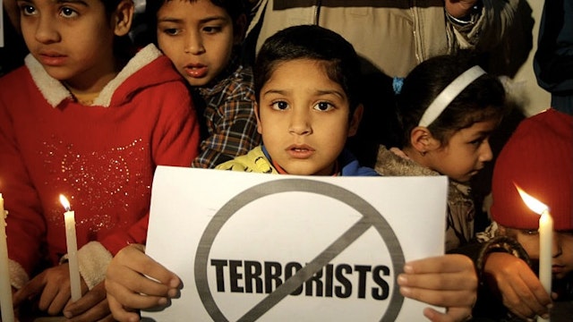 PESHAWAR, Dec. 16, 2015-- Pakistani children hold candles during a vigil to pay tribute to the victims of the Peshawar school massacre in Lahore, eastern Pakistan, on Dec. 15, 2015. Pakistan observed the first anniversary of the terrorist attack on an army-run school on Wednesday when a vast majority people feel the Taliban threat has been substantially reduced after post-attack operations. (Xinhua/Umar Qayyum)