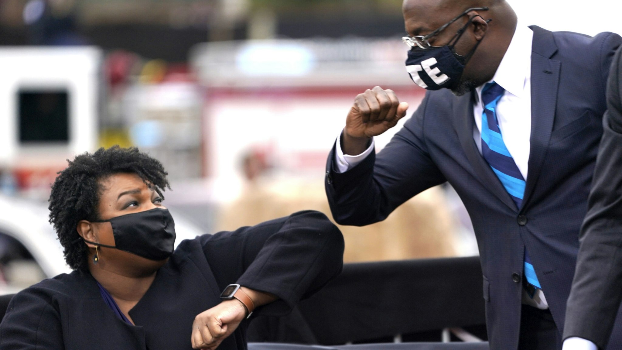 ATLANTA, GA - DECEMBER 15: U.S. Democratic Senate candidate Raphael Warnock (R) bumps elbows with Stacey Abrams (L) during a campaign rally with U.S. President-elect Joe Biden at Pullman Yard on December 15, 2020 in Atlanta, Georgia. Biden’s stop in Georgia comes less than a month before the January 5 runoff election for Senate candidates Jon Ossoff and Raphael Warnock as they try to unseat Republican incumbents Sen. David Perdue and Sen. Kelly Loeffler.