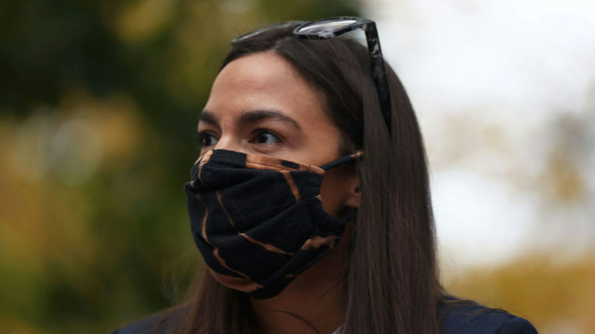 NEW YORK, NEW YORK - OCTOBER 27: Rep. Alexandria Ocasio-Cortez (D-NY) looks out towards a crowd during a food distribution event on October 27, 2020 in New York City. Rep. Alexandria Ocasio-Cortez (D-NY), New York state Assemblywoman Catalina Cruz, State Sen. Jessica Ramos, and Assembly District 34 candidate Jessica Gonzalez-Rojas, along with representatives from Make the Road NY helped to distribute food to families in Queens affected by economic distress due to the coronavirus (COVID-19) pandemic. (Photo by Michael M. Santiago/Getty Images)