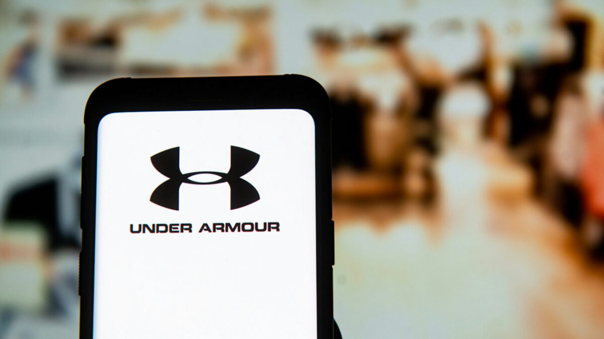 In this photo illustration an Under Armour logo seen displayed on a smartphone.