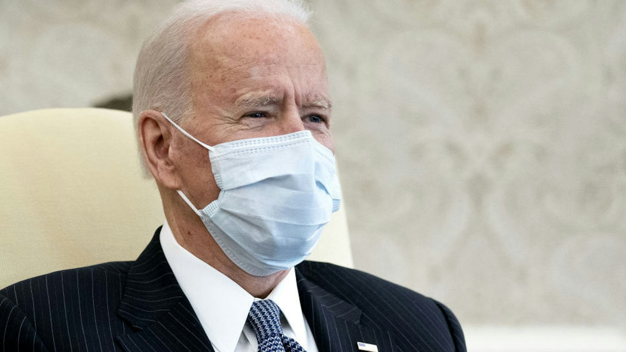 U.S. President Joe Biden wears a protective mask while meeting with Democratic senators in the Oval Office of the White House in Washington, D.C., U.S., on Wednesday, Feb. 3, 2021. The Senate on Tuesday began a process that would let Democrats pass Biden's $1.9 trillion stimulus without Republican votes.