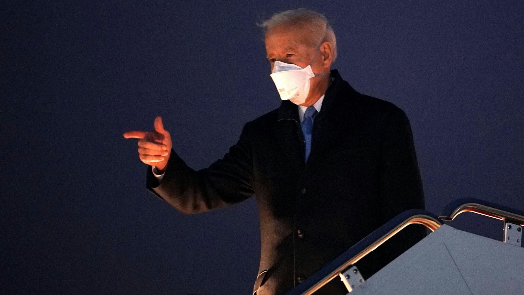 US-POLITICS-BIDEN US President Joe Biden gestures as he boards Air Force One before departing from Andrews Air Force Base in Maryland on February 12, 2021. - Biden is heading the Camp David presidential retreat where he is due to spend the weekend.