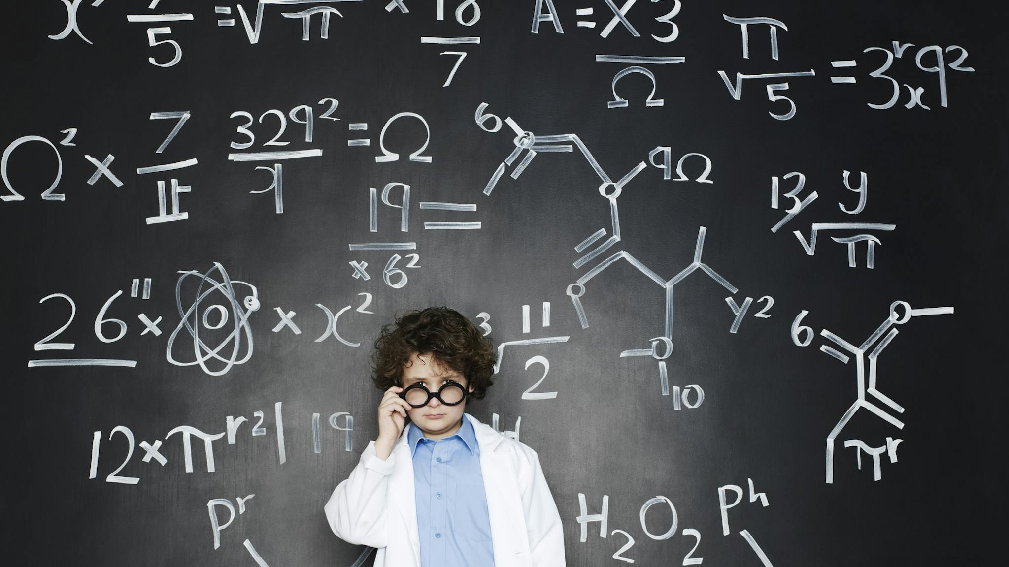Boy as a professor Boy as a professor with formulas behind him - stock photo