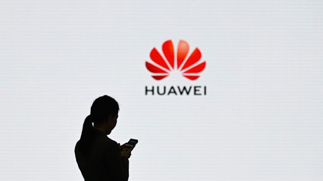 A staff member of Huawei uses her mobile phone at the Huawei Digital Transformation Showcase in Shenzhen, China's Guangdong province on March 6, 2019. - Chinese telecom giant Huawei insisted on March 6 its products feature no security "backdoors" for the government, as the normally secretive company gave foreign media a peek inside its state-of-the-art facilities.