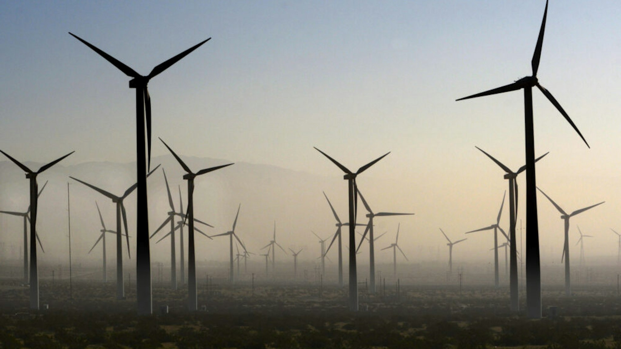 PALM SPRINGS, CALIFORNIA - FEBRUARY 27, 2019: Wind turbines generate electricity at the San Gorgonio Pass Wind Farm near Palm Springs, California, as a dust storm blows through the area. Located in the windy gap between Southern California's two highest mountains, the facility is one of three major wind farms in California.