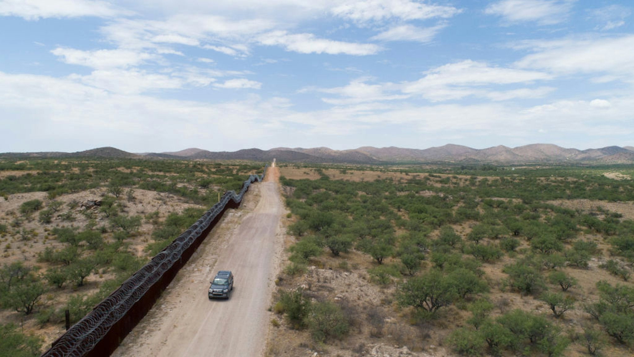 A Green Valley-Sahuarita Samaritans vehicle patrols the border fence in Sasabe, Arizona, on July 14, 2019. - Volunteers of the Green Valley-Sahuarita Samaritans offer humanitarian aid to migrants in the Arizona-Sonora borderlands with Mexico. (Photo by Daniel Woolfolk for AFP / AFP) (Photo credit should read DANIEL WOOLFOLK FOR AFP/AFP via Getty Images)