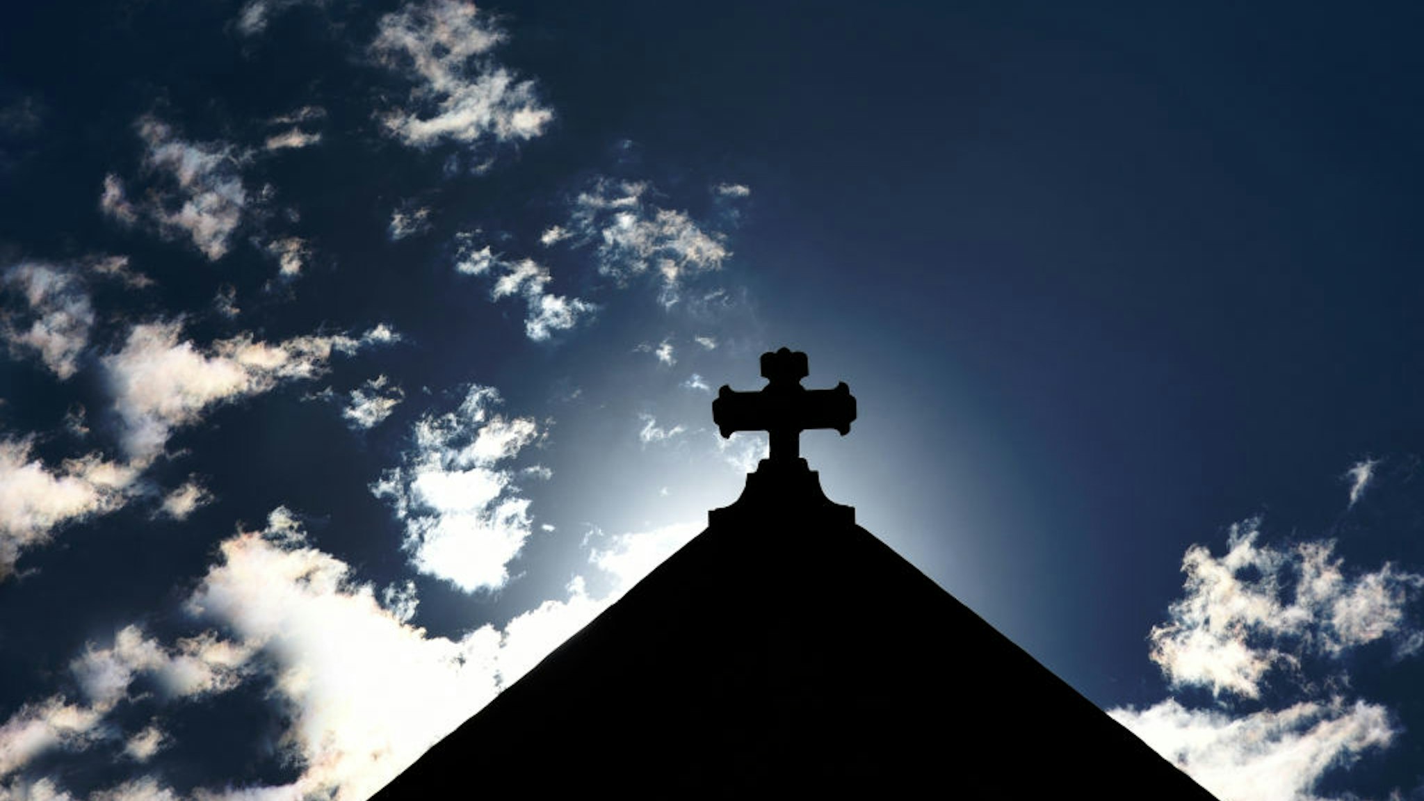 SANTA FE, NEW MEXICO - AUGUST 17, 2019: The morning sun rises behind a cross atop a Catholic church in Santa Fe, Newico. (Photo by Robert Alexander/Getty Images)