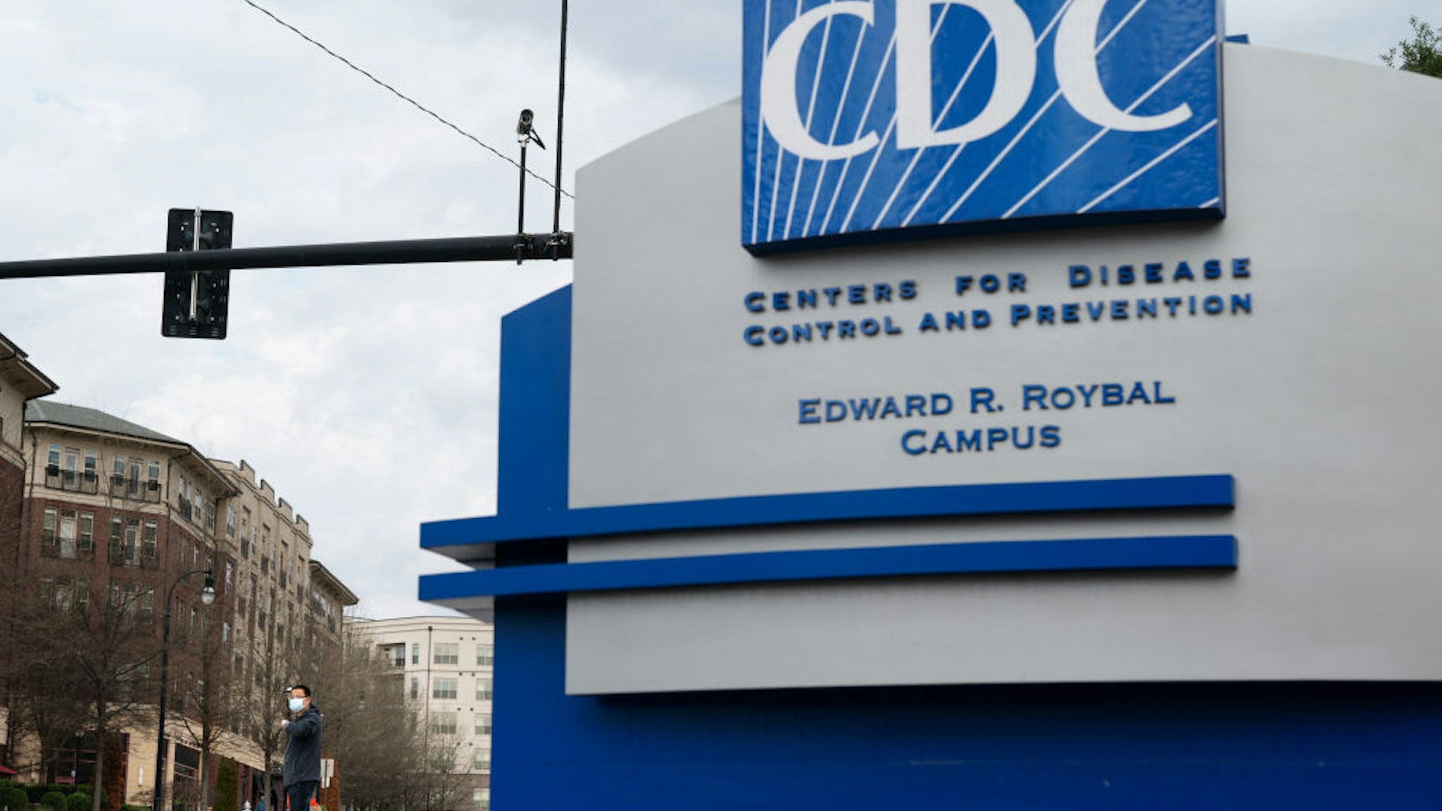 A pedestrian wearing a protective face mask walks past the Centers for Disease Control and Prevention (CDC) headquarters in Atlanta, Georgia, U.S, on Saturday, March 14, 2020.