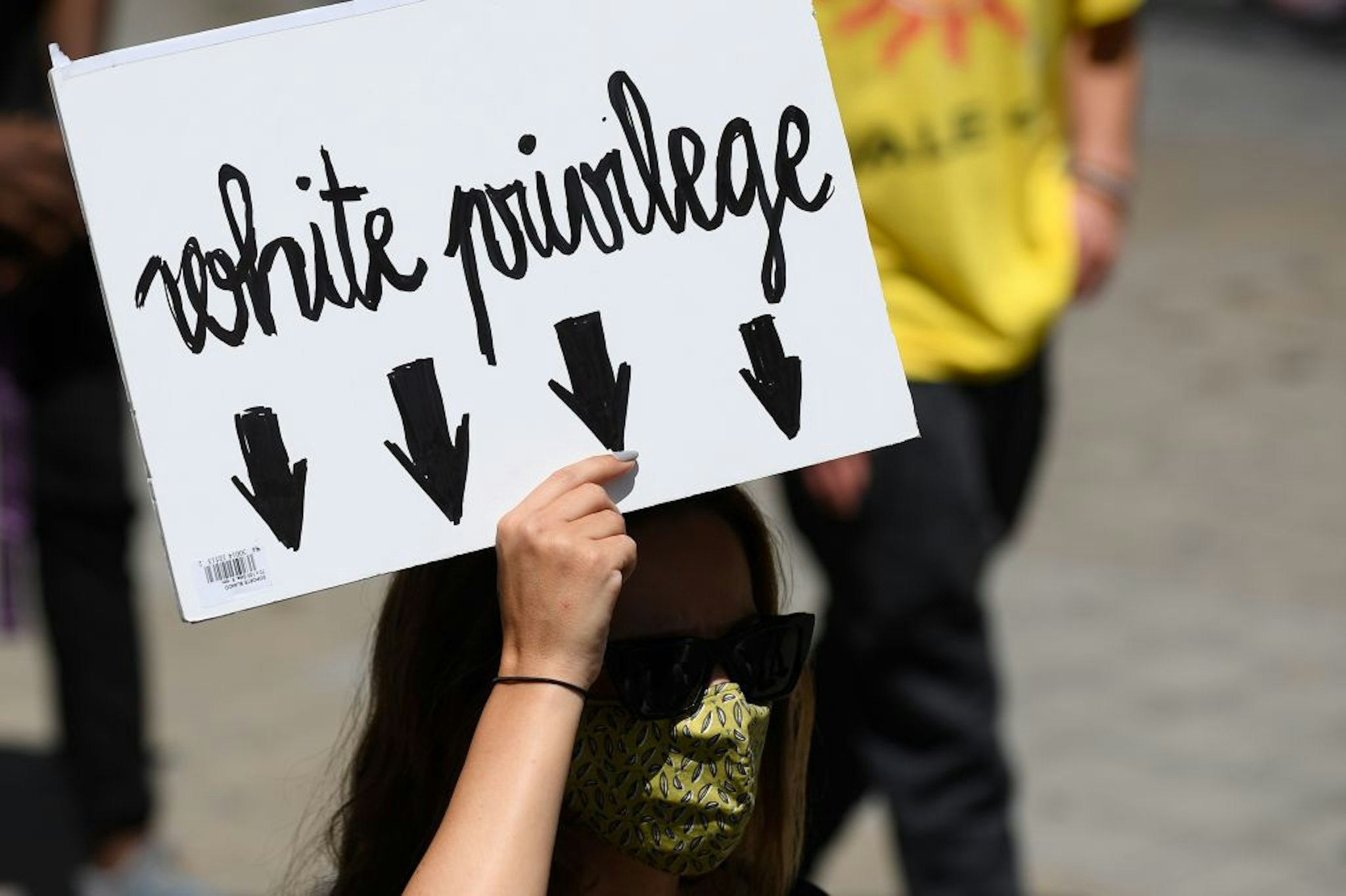 A woman holds a placard reading "White privilege" during a demonstration on June 14, 2020, in Barcelona, as part of the worldwide protests against racism and police brutality. - The protests are part of a worldwide movement following the killing in the United States of African-American man George Floyd who died after a white policeman knelt on his neck for several minutes. (Photo by Josep LAGO / AFP) (Photo by JOSEP LAGO/AFP via Getty Images)
