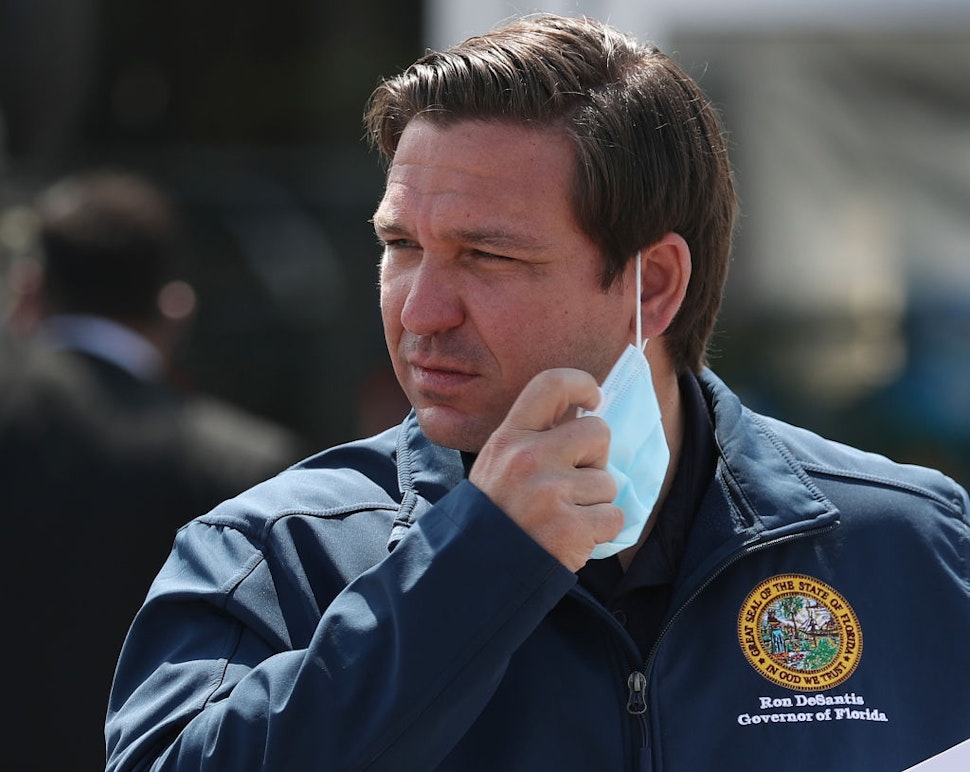 Florida Gov. Ron DeSantis takes his mask off as he prepares to speak during a press conference at the Hard Rock Stadium testing site on May 06, 2020 in Miami Gardens, Florida.