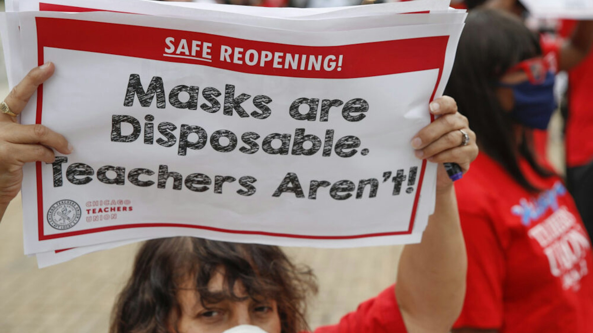 A woman holds a sign during the Occupy City Hall Protest and Car Caravan hosted by Chicago Teachers Union in Chicago, Illinois, on August 3, 2020. - Teachers and activists hold car caravan all over the country on August 3, 2020 to demand adequate classroom safety measures as schools debate reopening.