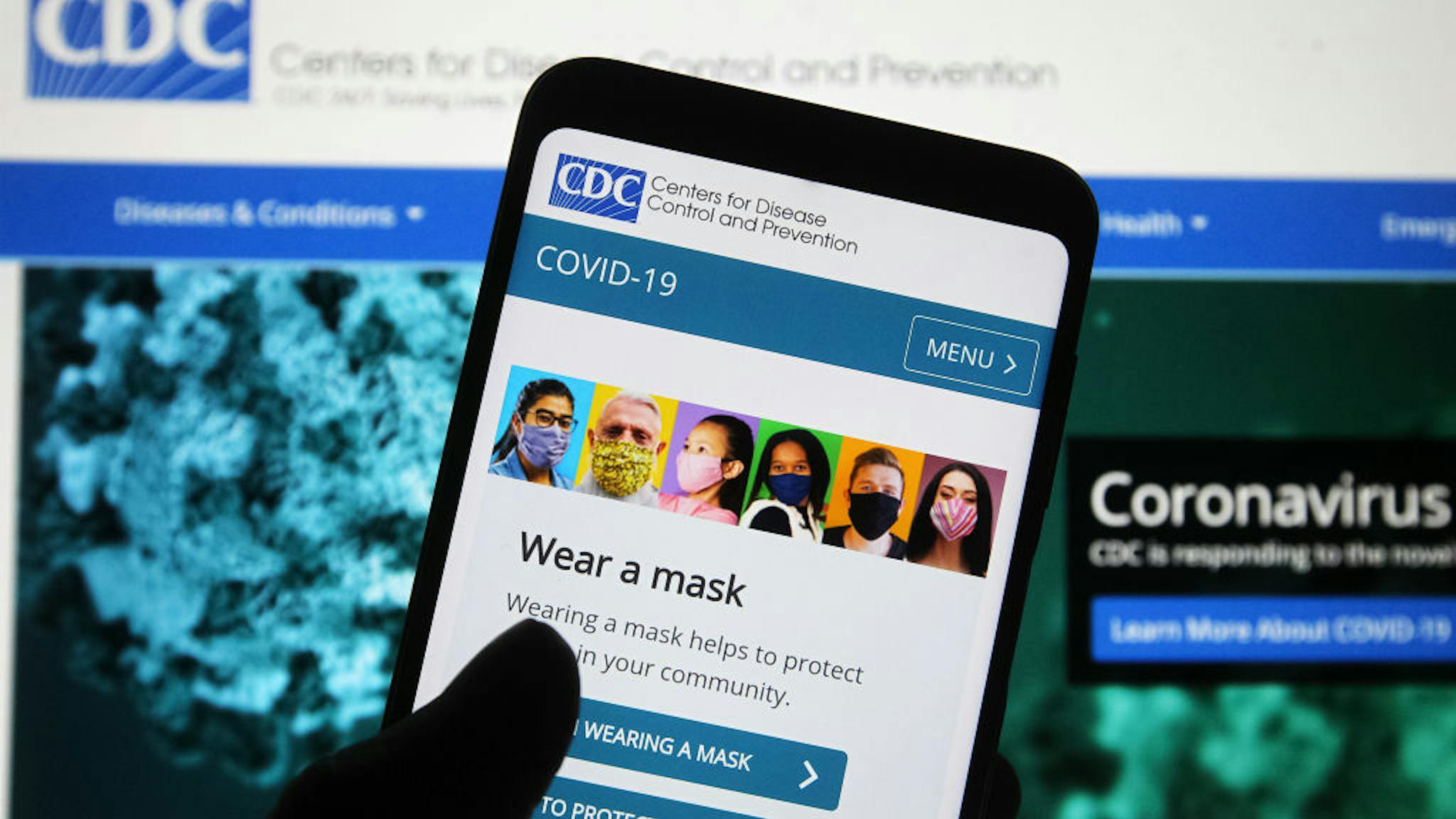 In this photo illustration Centers for Disease Control and UKRAINE - 2020/11/09: In this photo illustration Centers for Disease Control and Prevention (CDC) website with people wearing facemasks is seen displayed on a smartphone with a background of a computer screen. The Covid-19 global cases pass 50 million and 10 million in the U.S., according to internet online trackers of the coronavirus spread. (Photo Illustration by Pavlo Gonchar/SOPA Images/LightRocket via Getty Images)