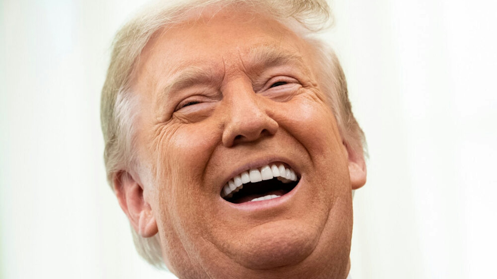 US President Donald Trump laughs during a Medal of Freedom ceremony for Lou Holtz in the Oval Office of the White House on December 3, 2020, in Washington, DC.