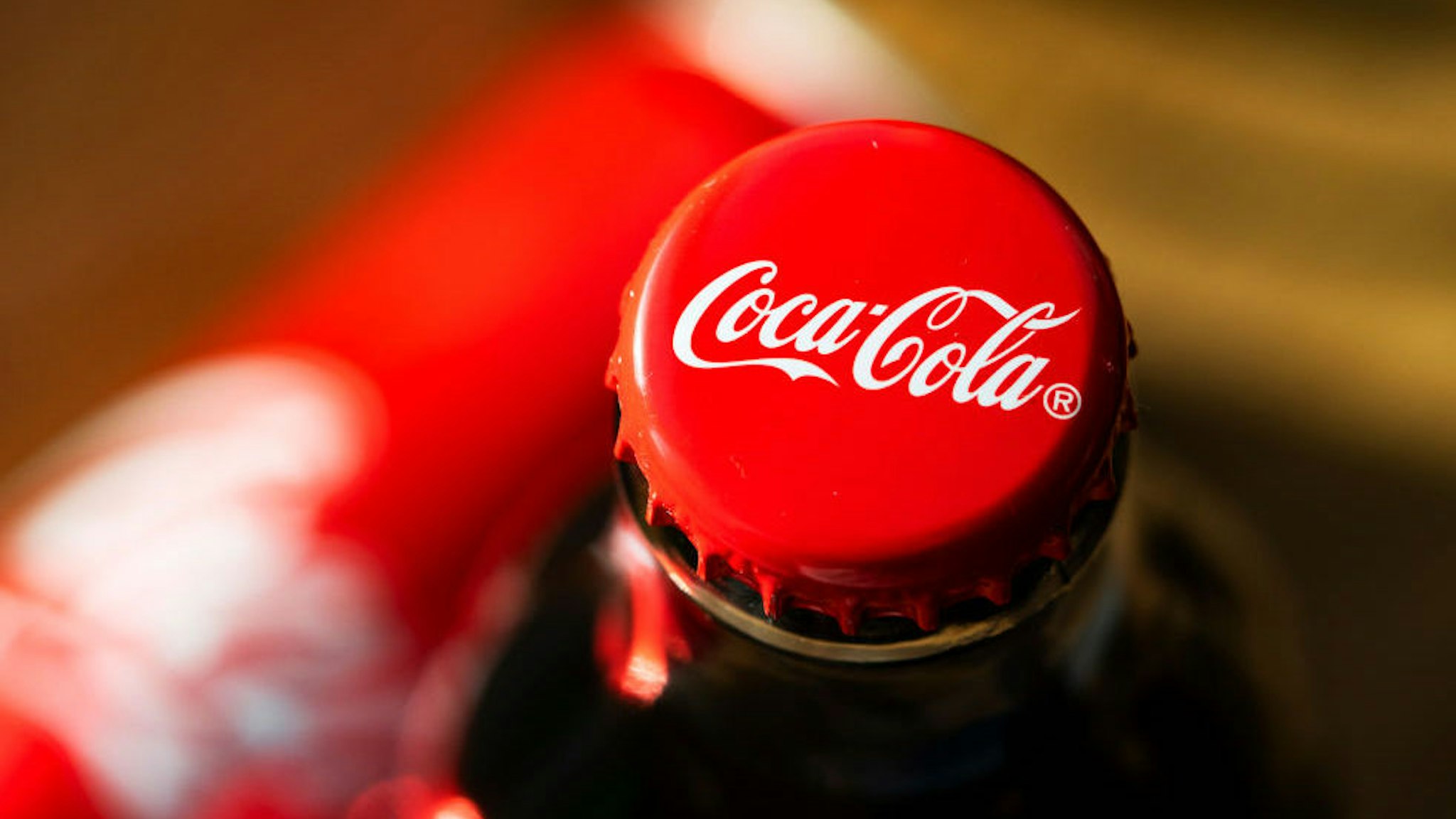 In this photo illustration a glass bottle of Coca-Cola seen displayed.