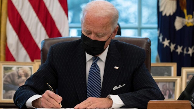 US President Joe Biden signs an Executive Order reversing Trump era ban on Transgender serving in the military while in the Oval Office of the White House in Washington, DC, on January 25, 2021.