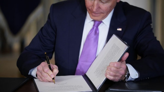 US President Joe Biden signs executive orders after speaking on racial equity in the State Dining Room of the White House in Washington, DC on January 26, 2021.
