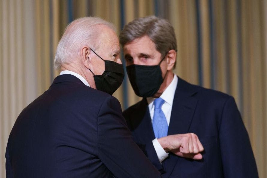TOPSHOT - US President Joe Biden greets Special Presidential Envoy for Climate John Kerry as he arrives to speak on climate change before signing executive orders in the State Dining Room of the White House in Washington, DC on January 27, 2021. (Photo by MANDEL NGAN / AFP) (Photo by MANDEL NGAN/AFP via Getty Images)