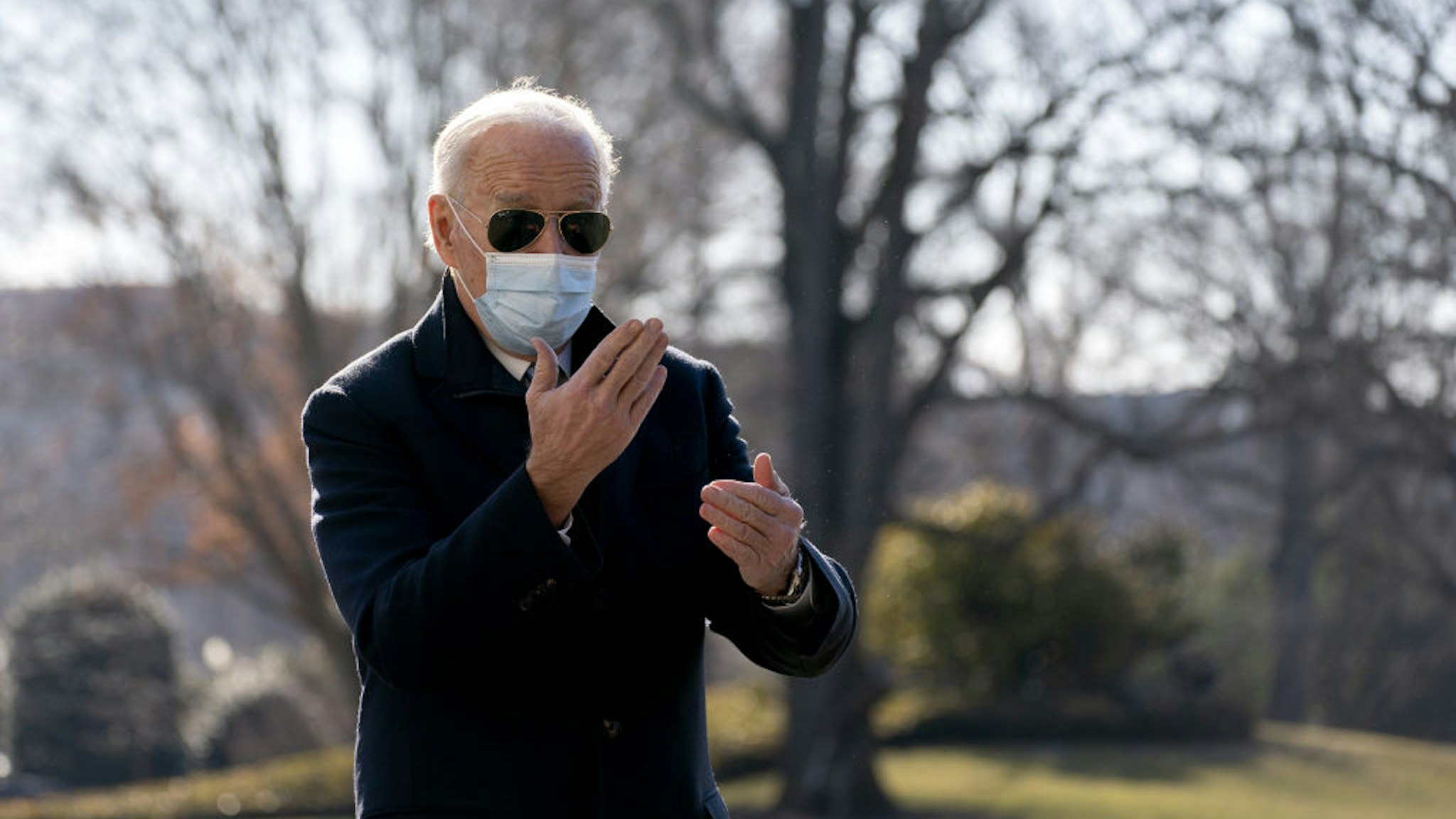 U.S. President Joe Biden wears a protective mask while speaking to members of the media on the South Lawn of the White House after arriving on Marine One in Washington, D.C., U.S., on Monday, Feb. 8, 2021.