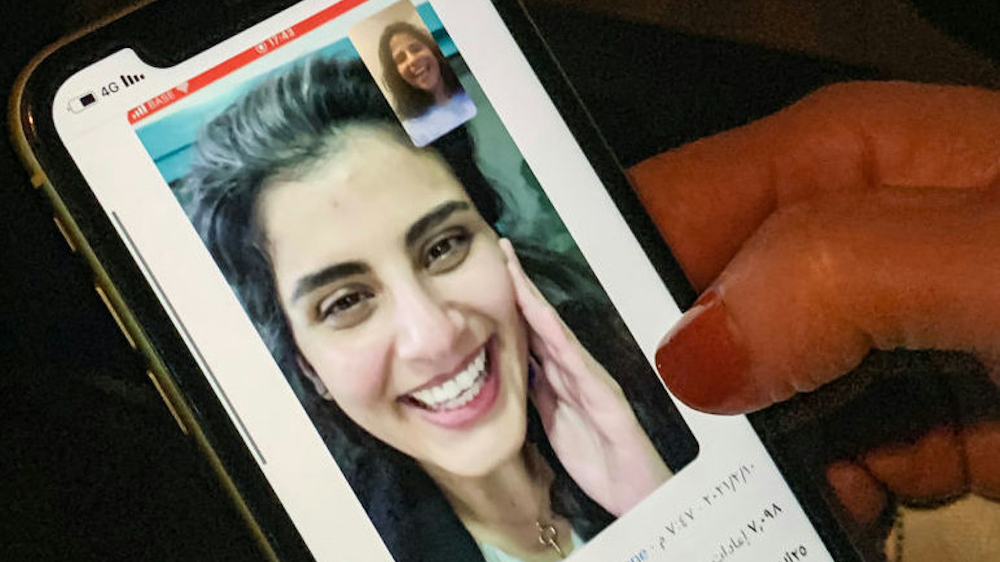 This picture taken February 10, 2021 in Saudi Arabia's capital Riyadh shows a woman viewing a tweet posted by the sister of Saudi activist Loujain al-Hathloul, Lina, showing a screenshot of them having a video call following Hathloul's release after nearly three years in detention. - Saudi authorities on February 10 released the prominent women's rights activist, her family said, as the kingdom comes under renewed US pressure over its human rights record. Hathloul, 31, was arrested in May 2018 with about a dozen other women activists just weeks before the historic lifting of a decades-long ban on female drivers, a reform they had long campaigned for, sparking a torrent of international criticism. (Photo by Fayez Nureldine / AFP) (Photo by FAYEZ NURELDINE/AFP via Getty Images)