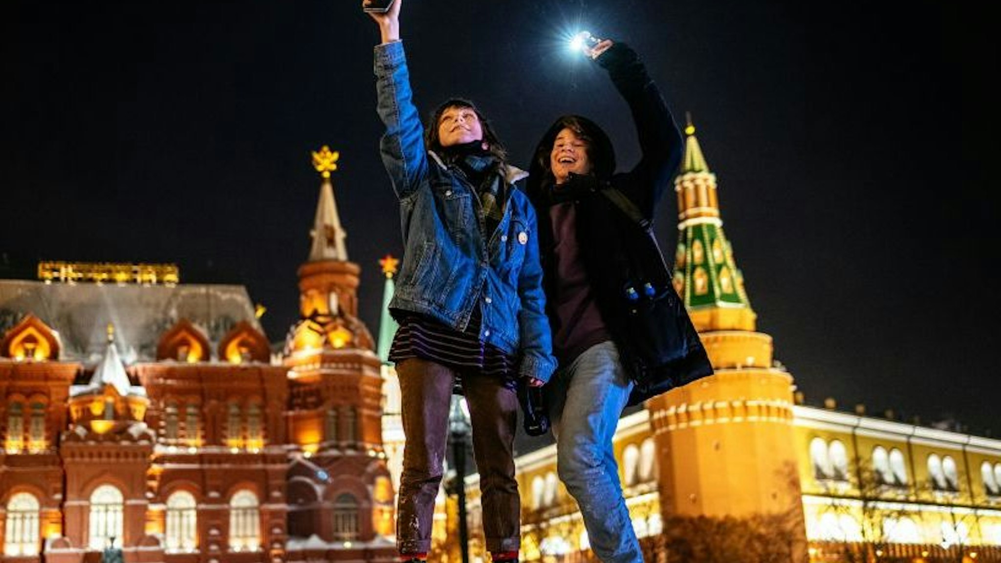 Young people turn on the flashlights of their mobile phones in support of jailed opposition politician Alexei Navalny near Red Square in Moscow on February 14, 2021. - The gathering came after authorities sentenced Navalny last week to nearly three years in prison and unleashed a crackdown on his supporters. Navalny's arrest on arrival back in Russia last month sparked nationwide protests that saw more than 10,000 people detained and led to allegations of police abuse. (Photo by Dimitar DILKOFF / AFP) (Photo by DIMITAR DILKOFF/AFP via Getty Images)