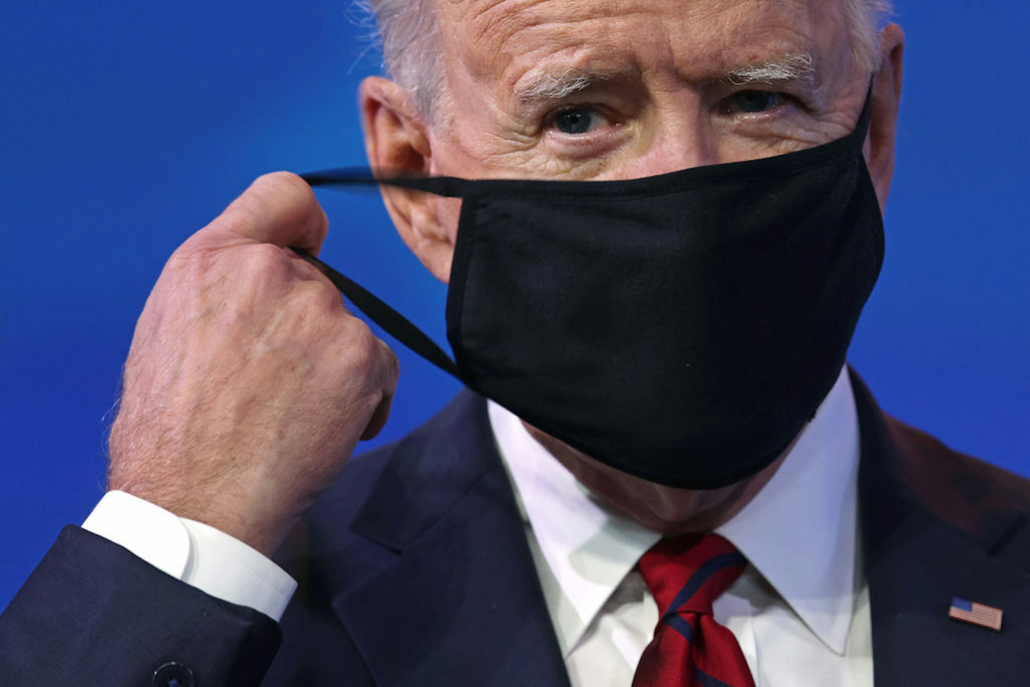 U.S. President-elect Joe Biden takes off his mask as he arrives at the Queen theater to lay out his plan on combating the coronavirus January 15, 2021 in Wilmington, Delaware.