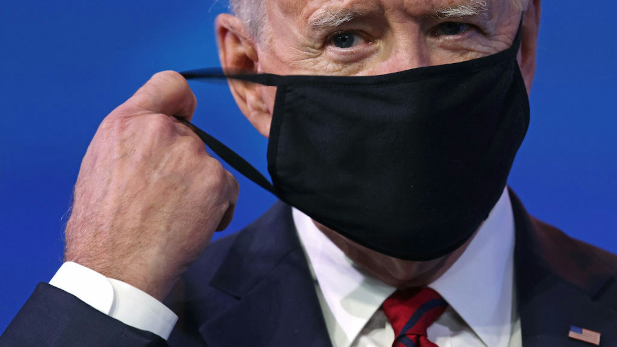 U.S. President-elect Joe Biden takes off his mask as he arrives at the Queen theater to lay out his plan on combating the coronavirus January 15, 2021 in Wilmington, Delaware.